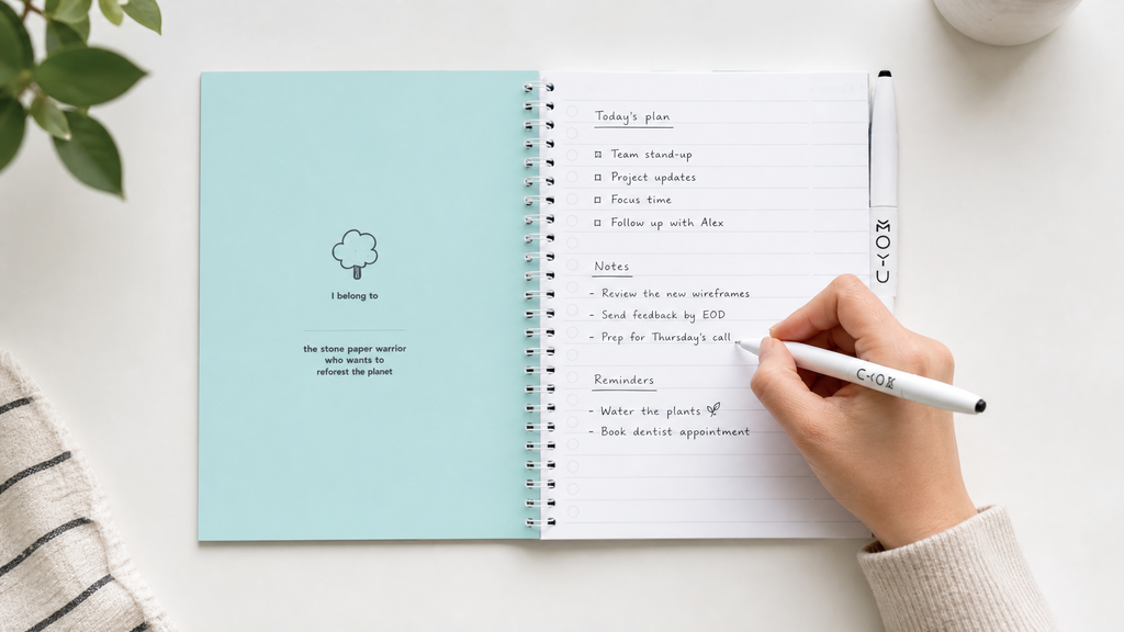 KI modifiziertes Bild: Hand schreibt in ein Notizbuch aus Steinpapier